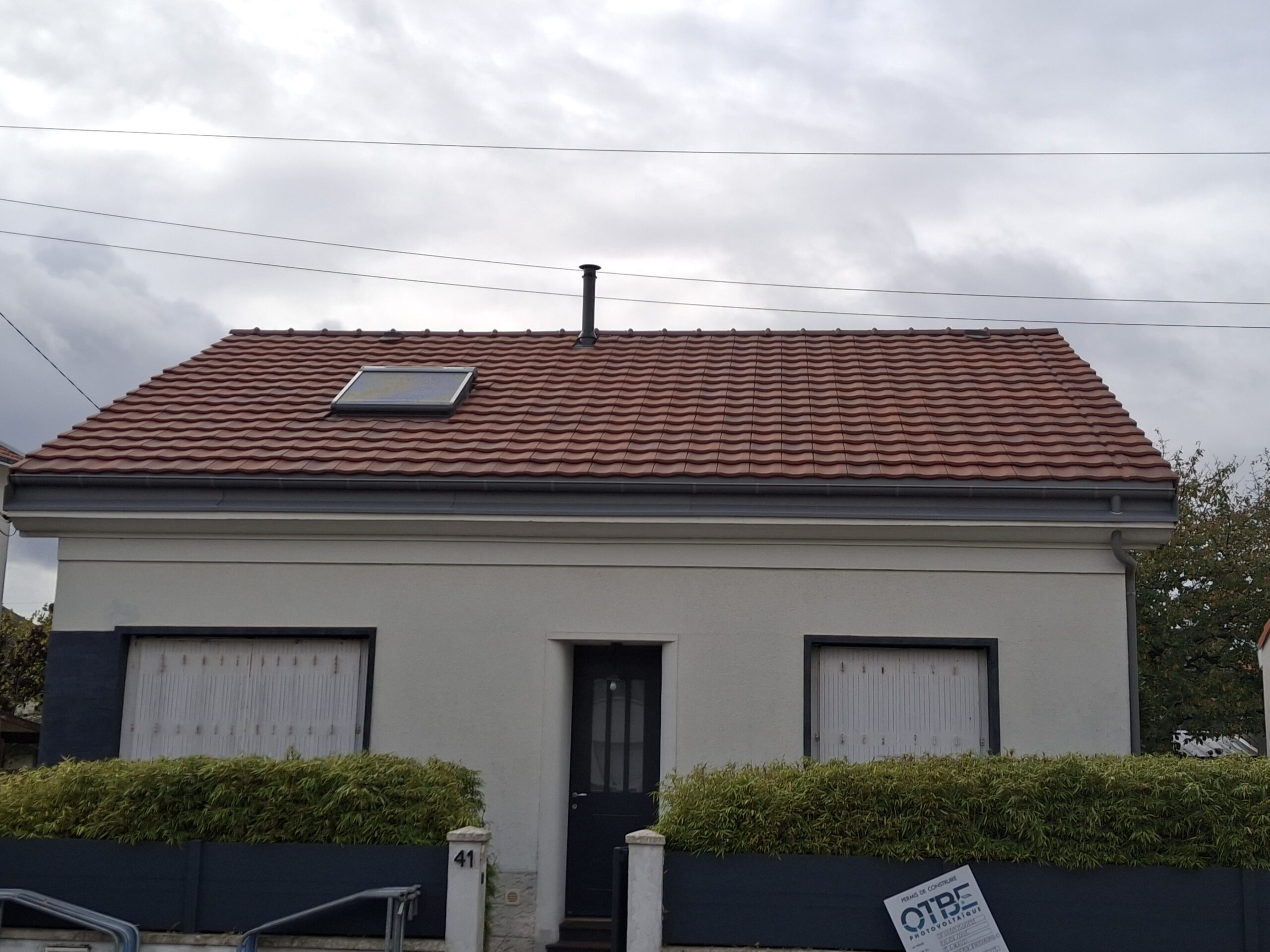 Façade avant d’une maison rénovée avec toiture en tuiles et isolation sarking à Nantes.