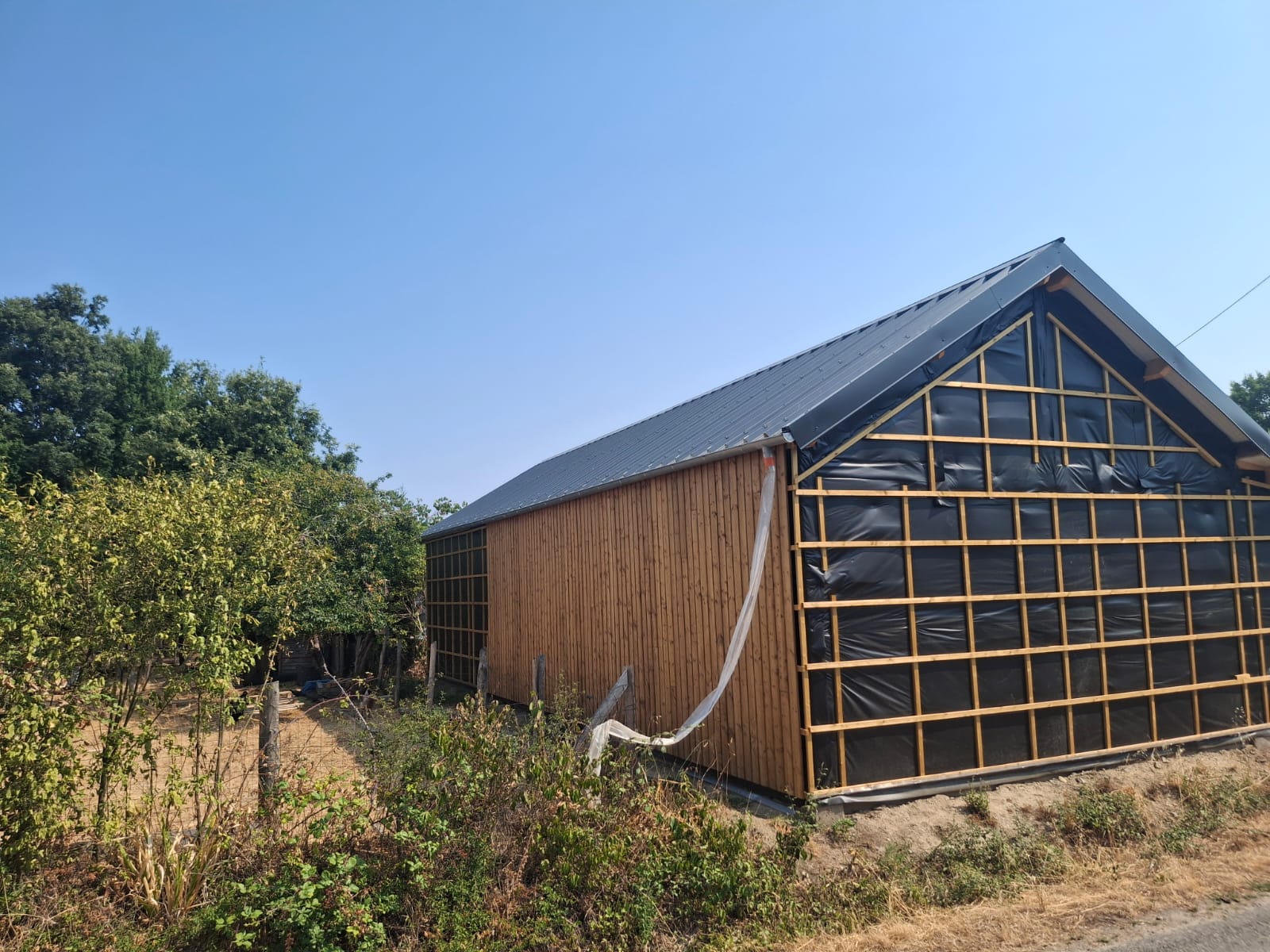 Grange réhabilitée par OTBE à Carquefou, bardage bois et toiture bac acier